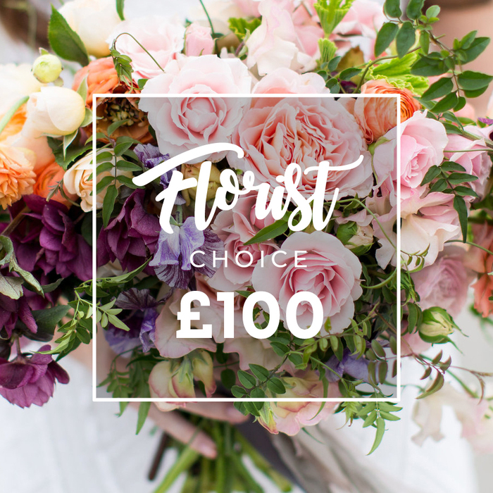 A lush, hand-tied bouquet fills the frame in a generous, garden-inspired composition selected by a florist. The dominant elements are large, soft pink garden roses-full, ruffled and fragrant-surrounded by pale purple-and-white sweet peas and coral-peach ranunculus that add delicate layers and warm highlights. Deep plum or burgundy hellebore-like blooms cluster toward the lower left, their brooding texture giving the design depth and contrast, while creamy white accents and varied green foliage - from slender vines to broader glossy leaves - braid through the arrangement, providing freshness and a natural, flowing silhouette. The photographer has superimposed a thin white square outline centrally across the bouquet; within it an elegant script reads Florist Choice and, set in bold sans-serif numerals underneath, the price ?100, a clear visual cue of a bespoke, florist-selected offering. A pair of hands, with a pale sleeve visible, gently supports the trimmed stems at the base; the softly blurred background keeps attention on the tactile surfaces and layered petals. As a local florist in Clerkenwell, Clerkenwell Flowers recognises how this design suits celebratory moments-from anniversaries and weddings to a thoughtful corporate gift-and how it travels well for same-day delivery across Clerkenwell, Farringdon and the surrounding Culture Mile. The overall mood is artisanal and romantic, a luxury yet personal bouquet that promises scent, texture and seasonal balance, thoughtfully prepared in our workshop and shown here as an expertly curated Florist Choice arrangement.