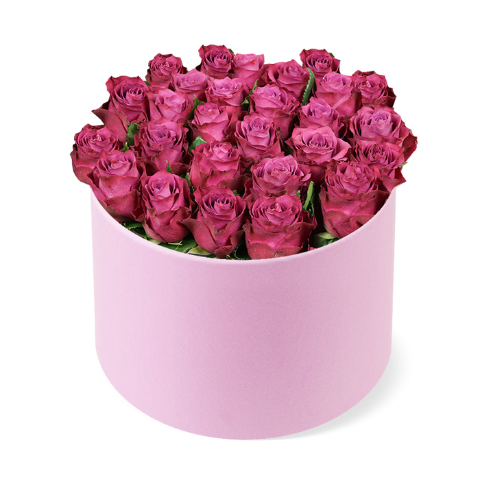 A couture bouquet of deep magenta roses sits in a pale pink cylindrical hat box, the dome formed with precision and quiet drama. Dozens of blooms are packed with careful symmetry, their petals curling inward to create a plush, crown-like silhouette that fills the interior and nearly hides the box's lip. Between the heads, only a few hints of dark green foliage peek out, serving as gentle punctuation rather than a dominant chorus. The box's smooth, matte finish in a soft pink tone contrasts with the saturated colour of the roses, turning texture into a high-fashion element that invites touch without compromising the blooms' integrity. The arrangement is photographed against a clean, white backdrop that makes the colour sing in three dimensions, every petal catching the light as if it were a velvet curtain drawn slightly apart. This piece speaks of romance and luxury, a gift designed for anniversaries, refined celebrations, or a lavish home welcome. In Clerkenwell, it would align beautifully with the city's boutique hotels and design studios along Cow Lane and St John's Square, and is available for same-day delivery to surrounding areas such as Holborn and Farringdon. Crafted with meticulous care by a local florist, you can sense the years of experience in the balance of form and colour, in the glow of the magenta petals, and in the quiet elegance that lingers after the first glance.