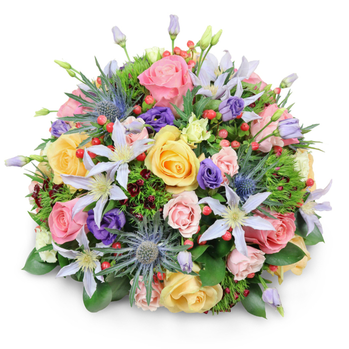 A meticulously crafted, domed bouquet of mixed flowers is shown against a bright white background, casting only the faintest shadow and allowing every bloom to stand out as if suspended in space. The design is lush and abundant, dominated by garden roses in pastel shades of blush pink, warm yellow, and creamy peach, their petals forming intricate, spiralling rosettes that convey softness and romance. Interwoven among these classic blooms are star-like clematis flowers, their slender petals painted in gentle hues of lavender and pale violet, each surrounding a luminous white or golden-yellow center that acts as a natural focal point. Adding a striking counterpoint are several stems of blue eryngium, or sea holly, with their bristling, metallic blue-grey heads and prickly collars, introducing a wild, textural energy reminiscent of the contrast between Clerkenwell's old brick buildings and its sleek modern offices. Smaller, cup-shaped lisianthus in tones of deep purple and soft green nestle between the larger flowers, filling in the gaps and guiding the eye around the arrangement. Scattered through the bouquet, bright red hypericum berries cluster in small sprays, their glossy surfaces catching the light and adding lively pops of colour. The base is enveloped in an array of greenery: from broader, satin-finished leaves to fine, feathery foliage, and hints of dark, burgundy-tinged greens that add depth and a sense of quiet luxury. The overall effect is harmonious yet complex, like a curated garden plucked at peak bloom and shaped into an opulent centerpiece. It's easy to imagine this bouquet gracing a dining table in a Clerkenwell townhouse or arriving as a same-day delivery near St John Street, expressing heartfelt congratulations, sympathy, or affection with understated elegance.