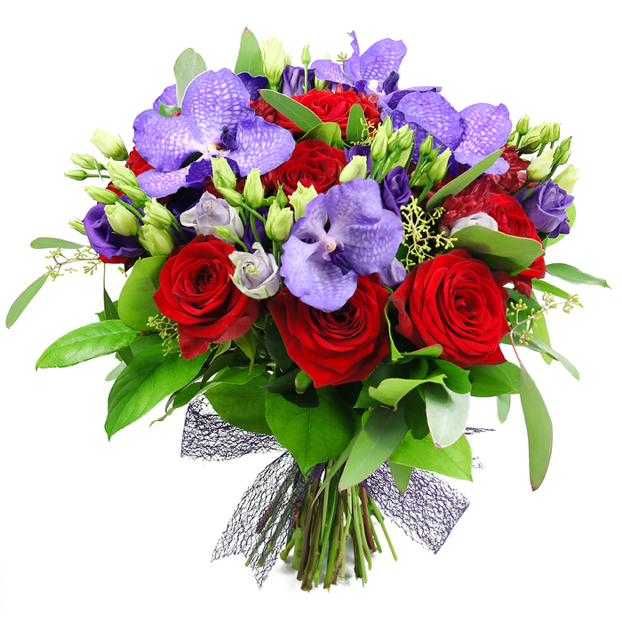 An opulent statement from Clerkenwell Flowers, this bouquet commands attention against a clean white backdrop. Deep red roses rise in velvety spirals, their color rich and hypnotic, while purple Vanda orchids lend exotic elegance with broad petals and speckled artistry. Soft lisianthus (eustoma) in lilac and indigo fill the spaces, some buds barely open, contributing a light, airy counterpoint. The greenery is lush and generous-a mix of large glossy leaves and slender sprigs that create a solid green frame and a sense of natural abundance. The stems are gathered at the base and tied with a dark, near-black mesh ribbon, a contemporary finishing touch that lets the blooms speak for themselves. This luxurious bouquet is ideal for anniversaries, Valentine's Day, or a grand birthday surprise, and it would happily grace a dining table near Clerkenwell Green, Leather Lane, or Farringdon Road. It is available for same-day delivery across Clerkenwell and surrounding districts, a testament to Clerkenwell Flowers' commitment to freshness, texture, and timeless romance.