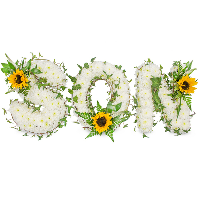 This three-dimensional memorial arrangement spells out the word SON in strong, capital letters and is presented against a pure white studio background so every floral element reads precisely. Each letter-S, O and N-is constructed from a tight, lush mass of small white chrysanthemums; the petals are layered densely, producing a soft, cloud-like surface whose rounded texture reads as both delicate and enduring. Interlaced through the white chrysanthemum beds are deep green ivy stems, their characteristic lobed leaves curling and weaving to create natural contours and shadow, while lighter fern fronds and pointed foliage give additional structure and a fresh botanical contrast. Strategically positioned to catch the eye, three large sunflowers punctuate the design: one placed on the upper-left curve of the S, another cradled at the bottom centre of the O amongst verdant fronds, and a third accenting the upper-right of the N. Their radiant yellow petals frame bold dark brown centres, offering a warm, hopeful counterpoint to the solemn white base. The lighting is soft and even, eliminating harsh shadows so the textures-from the chrysanthemums' velvety faces to the sunflowers' coarse centres-are clearly visible. This arrangement reflects the considered craftsmanship typical of Clerkenwell florists working close to Smithfield Market and Leather Lane: composed, respectful, and intended for funeral tributes or commemorative services. It speaks of purity, memory and the small brightness of cherished recollections during times of loss.