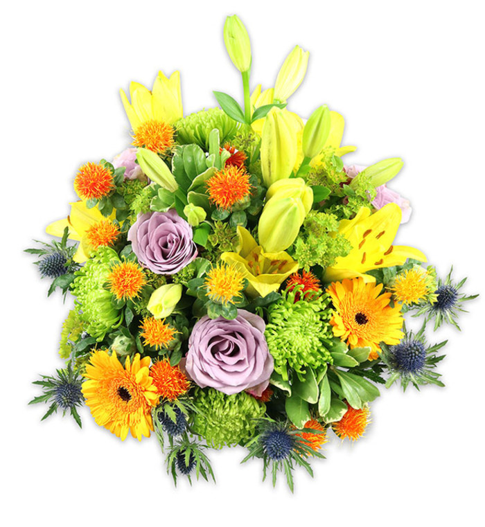 A vibrant, densely arranged bouquet sits against pure white, each bloom chosen for colour, texture and movement. Upright yellow Asiatic lilies create height and drama: some are fully open, displaying freckled petals and exposed stamens, while others remain sleek chartreuse buds that promise unfolding life. Two or more soft lavender roses are placed quietly at the centre, their spiralled petals calming the exuberant palette with a touch of classic romance. Bright orange Gerbera daisies fan outward with flat, sun-like faces and dark centres, drawing the eye across the composition. Plush lime-green button chrysanthemums give the bouquet its substantial, ruffled volume, their spiky, moss-like heads filling gaps and adding tactile interest. Small, round orange and gold accent blooms-suggestive of Craspedia or similar textured spikes-dot the massing with cheerful, bouncy detail. Cool, steel-blue Eryngium thistles emerge at the lower and side edges, their spiky, architectural forms providing striking contrast to the softer petals and introducing a rustic, coastal note. A mixture of glossy and matte greens-broad lily leaves and finer filler foliage-frames the flowers and creates depth and cohesion. Bathed in soft studio light, the arrangement conveys warmth and celebration while retaining an elegant sensibility, perfect for a dinner table in Clerkenwell or as a thoughtful gift delivered to a flat near Leather Lane market. The scent of lilies and the gentle perfume of roses would subtly perfume a room, making this bouquet suitable for anniversaries, congratulations, or heartfelt remembrance.