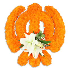 The composition centres on a sacred Sikh emblem-painstakingly formed from densely packed, bright orange marigold flowers-shaped with the precision of a traditional Khanda and set on a clean white background. Each tiny marigold contributes to a plush, three-dimensional tapestry: the circular chakkar appears as a luminous ring, the crossed kirpans as articulated orange bands, and the upright khanda as a bold, narrow column of blossom. Nestled at the intersection, a thoughtful cluster of white lilies provides a serene focal point: two prominent lilies unfurl in full bloom, their petals soft and slightly recurved to display pale green and yellow stamens, surrounded by a handful of smaller lily buds awaiting bloom. Fine sprays of baby's breath (gypsophila) and fresh deep-green foliage-sharply pointed leaves that might come from salal or seasonal greenery-add contrast and breathe space into the vivid orange field. The arrangement casts a faint shadow on the white plane, revealing that this is a carefully constructed, freestanding piece meant to be viewed from all sides. The juxtaposition of warm marigolds and cool white lilies creates a calm, ceremonial mood: celebratory yet contemplative, fragrant with the marigolds' earthy sweetness tempered by the lilies' clean perfume. As a Clerkenwell floral maker I often source similar blooms from nearby Smithfield and Leather Lane stalls for cultural events; this piece would be equally at home in a Gurdwara, at a festival table, or as a dignified civic tribute near Farringdon Station. Clerkenwell Flowers crafts such symbols with steady hands and respect for tradition.