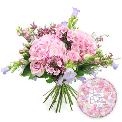 Against a bright white background, a luxurious hand-tied birthday bouquet appears as though freshly placed on a counter in a Clerkenwell studio, its colours breathing life into the scene. The arrangement is dominated by large, pillowy heads of pale blush hydrangea, each rounded cluster made of countless soft petals that create a gently rippled, cloud-like surface. Between these generous blooms nestle soft pink roses, some unfurled to reveal layered, spiralling centres, others still cupped in bud, adding a sense of movement and time to the composition. Threaded through the pinks are tiny star-shaped flowers in deeper fuchsia or magenta tones, likely waxflowers, which lend an almost confetti-like effect, echoing the excitement of a birthday gathering in one of the cafés off St John Street. Vertical accents come from graceful campanula stems, their bell-shaped flowers in lavender and light purple nodding delicately above the main dome of the bouquet, adding cool undertones and a slightly wild, garden-picked charm. Fresh green foliage encircles and supports the blooms, with glossy leaves and slimmer, more feathery stems creating layers of texture that frame the soft colours and enhance their pastel glow. The bouquet's stems are tightly yet naturally gathered at the base, showcasing the hand-tied technique used by Clerkenwell florists who know how to balance abundance with elegance. To the lower right, a shiny foil balloon adds an unmistakable birthday note: round and reflective, patterned with petite roses and floral motifs in pink, cream, and lilac, and finished with an ornate "Happy Birthday" message in flowing script. The image captures a thoughtful birthday gift set, perfect for same-day delivery around Clerkenwell's design studios, townhouses, and offices near Farringdon or Old Street.