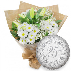 Elegant white anniversary bouquet and silver foil balloon styled as if ready for local delivery around Clerkenwell Green. The photograph focuses on a lush, hand-tied arrangement dominated by white chrysanthemum daisies, their round petals radiating around golden-yellow centres like tiny suns. Between these cheerful heads sit long, closed white lily buds, cool and sculptural, edged with a whisper of pale green that suggests they will open slowly over the coming days. Airy clouds of baby's breath drift through the bouquet, their tiny white blossoms softening the stronger shapes and creating a light, romantic haze. Rich, dark green leaves emerge at intervals, grounding the composition and framing the bright whites with natural depth. The stems are carefully wrapped in a layer of clear cellophane for protection, then enclosed in folded brown kraft paper that feels organic and understated, much like something picked up from a trusted local florist on your way home from Farringdon Station. The paper is folded neatly around the base, giving the bouquet a structured, gift-ready silhouette. To the lower right of the flowers sits a shining round silver foil balloon. Its surface features a refined pattern of scrolling motifs and stylised florals in slightly darker silver, creating an impression of vintage engraving. In its centre, the words "25th" appear in graceful script, while the background carries a subtle repeat of "Happy Anniversary" in pale grey. Together, bouquet and balloon convey a quiet yet unmistakable celebration of a Silver Anniversary or 25-year milestone in the heart of Clerkenwell.