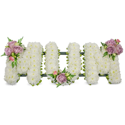 This carefully composed sympathy tribute spells 'MUM' in elegant capital letters, each formed from tightly packed white chrysanthemums that create a soft, tactile blanket of petals across the three-dimensional shapes. The luminous white suggests purity and steady calm, while three small, artfully placed clusters of soft lavender and pale pink roses add a restrained, consoling accent: one cluster sits on the upper left arm of the first 'M', another nestles in the dip of the 'U', and a third highlights the upper right arm of the final 'M'. Bright green foliage-slender fern fronds and lighter, fresh leaves-frames the pastel roses and slips between the chrysanthemums, giving the arrangement gentle movement and a natural, living contrast to the crisp whites. A dark green support, visible as a narrow outline at the base of each letter, hints at ribbon or moss-wrapped foam that secures the design and keeps the letters aligned for standing display. The scent is quietly floral: the cool, powdery note of chrysanthemum below and the warm, velvety rose above, together forming a respectful, consoling aroma. Designed for funeral services, graveside dedications or wakes, this tribute offers a dignified expression of love and mourning for a mother or maternal figure. As a local florist who has delivered similar tributes to churches around Leather Lane and the Barbican, I make sure the piece reads clearly from the front and sits with composure near a casket or memorial table.