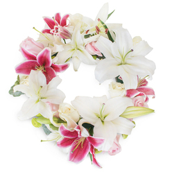 Capturing the artistry and empathy of Clerkenwell's florists, this dignified funeral wreath forms a perfect circle, symbolising the continual bonds of remembrance within the local community. The arrangement is profoundly lush, dominated by elegant white lilies whose unfurled petals glisten with natural freshness, each bloom radiating peace and gentle illumination. Alongside these, fuchsia pink lilies blaze with passion; their rich, magenta hues enhanced by delicate speckling, offering moments of bold contrast that evoke cherished memories amid sorrow. Between these statement lilies nestle tightly furled roses in shades of blush and creamy white, their smooth textures lending an intimate softness and a whisper of romance to the wreath. Slender green foliage, resembling the foliage of nearby Spa Fields or Clerkenwell Green, emerges gracefully, lending depth and natural structure. These gentle natural accents and the expertly woven circular form suggest both unity and hope, while soft ambient lighting underscores the arrangement's tactile richness and intricate detail. Evoking comfort and heartfelt tribute, this locally inspired wreath is ideal for moments focused on solace and loving remembrance, meticulously crafted by Clerkenwell Flowers for neighbours in need of comfort and commemoration.