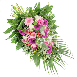 A large, hand-crafted funeral spray rests on a white backdrop, its shape drifting diagonally from top left to bottom right like a soft river of colour and foliage. The arrangement balances tenderness and richness, blending gentle pinks, vivid fuchsias, purples, and clean whites against a lush green foundation. At its heart, generous gerbera daisies, some in pale pastel pink and others in saturated magenta, open wide and cheerful, becoming natural focal points that draw the gaze along the length of the spray. Pink roses are nestled between them, their tightly wound petals suggesting both grace and quiet strength, a fitting tribute for a farewell gathering in Clerkenwell, perhaps near St John Street or Farringdon.   

Between the larger blooms, clusters of soft white flowers-likely carnations or small chrysanthemums-create a cushion of texture, while tiny white daisy-like blossoms ripple lightly through the design, almost like scattered stars. A scattering of bright red hypericum berries adds glints of colour and a berry-smooth texture that stands out among the petals. Supporting all of this is an abundant bed of foliage: broad, glossy dark green leaves provide stability; feathery, bright green ferns soften the outline; and cool, silvery eucalyptus leaves introduce a modern, fragrant note. At the lower right, graceful palm fronds extend outward, emphasising the cascading, elongated silhouette so often chosen for casket sprays and standing tributes. The visible stems at the upper left show where the florist has bound the design, a reminder of the care invested in each placement. This piece feels calm, dignified, and heartfelt, an arrangement that would sit beautifully at a memorial or funeral service, offering comfort and a sense of beauty to families across Clerkenwell.