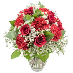 Against a bright white background, a carefully composed bouquet of red and white flowers glows with warmth, arranged in a clear glass vase that allows every tidy stem to be seen. At the centre, velvety red roses curl into tight, elegant spirals, their deep colour suggesting romance and devotion, much like a thoughtful gift exchanged after dinner in a Clerkenwell restaurant near St John Street. Surrounding them, abundant red carnations unfold in soft, ruffled layers, each bloom adding gentle fullness and a sense of joyful celebration. Between the crimson flowers, tiny white stars of baby's breath appear in generous clusters, creating a misty, cloud-like layer that lightens the arrangement and gives it an almost ethereal softness. Fresh green foliage weaves throughout the design, with classic dark rose leaves contrasting beautifully against rounded, silvery eucalyptus that adds a cool, modern touch reminiscent of the calm pockets of green around Spa Fields. The vase itself is simple and slightly flared at the top, filled with clear water that reflects the stems and hints at the bouquet's freshness and professional preparation. The overall shape is round and full, with no empty spaces, creating a polished, timeless look suitable for a romantic surprise, a heartfelt thank you, or a special milestone. This arrangement feels equally at home brightening a modern Clerkenwell loft studio as it does resting on a reception desk near Farringdon, quietly expressing love, admiration, and enduring connection through its rich reds and gentle whites.