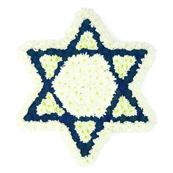 A striking Star of David sympathy tribute, carefully photographed against a plain white backdrop, showcases the calm balance of white and deep blue flowers arranged with exacting care. The six-pointed Jewish symbol appears almost like a floral mosaic, every petal deliberately placed so that the star's clean geometry remains sharp and clearly defined. Around the very edge, a thick collar of soft white chrysanthemum-style blooms creates a gentle frame, each floret blending seamlessly into the next so that the perimeter feels like a cloud of petals resting lightly on the background. Inside this halo, a bold white hexagon sits at the heart of the design, a bright focal point symbolising purity and remembrance. Surrounding it, the triangular arms of the star are packed with velvety navy or indigo blossoms that provide an intense contrast, reminiscent of evening skies over Clerkenwell's historic streets. At the inner base of each arm, a small white triangle is inset into the blue, adding rhythm and complexity to the pattern, as though the colours are quietly interwoven in conversation. The flowers look freshly cut and cool to the touch, their subtle green stems hidden beneath the surface so that only the interplay of colour and texture is visible. Crafted for Jewish funerals, memorial services, or shiva, this piece would feel fitting in a Clerkenwell townhouse close to Exmouth Market or in a local chapel, its stillness inviting reflection. The arrangement communicates deep respect, love, and heritage without a single word, echoing generations of tradition through its serene, carefully measured design.