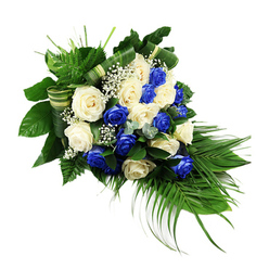 A dignified blue-and-white funeral spray rests against a stark white backdrop, its elegant, elongated form echoing the gentle curve of a river as it narrows and flows away. At the centre of this Clerkenwell-inspired design, around two dozen roses are arranged with deliberate care: rich sapphire blue blooms sit beside soft ivory and creamy white roses, each head fully open so that the layered petals can be clearly seen. The cool blue tones bring a sense of depth and reflection, while the white roses soften the composition with feelings of purity, remembrance, and gentle farewell. Between the larger flowers, clusters of white baby's breath create airy pockets of light, as if small clouds have settled between the petals. Supporting this tapestry of colour is a strong base of mixed greenery. Dark, glossy leaves form a dense foundation at the top left, bright green ferns lift and soften the edges, and long, slender palm fronds sweep down from the lower right to form the cascading teardrop outline. Here and there, sprigs of bluish-green eucalyptus-like foliage introduce a slightly cooler, misty tone, adding texture without overwhelming the roses. Broad leaves are carefully folded into striped green-and-cream bands and woven through the middle, adding a modern, structured detail that showcases the skill of an experienced florist. The whole arrangement feels composed and serene, suitable for a funeral or memorial gathering in Clerkenwell or along nearby Rosebery Avenue, a heartfelt expression of sympathy that speaks quietly of respect, loyalty, and enduring love.