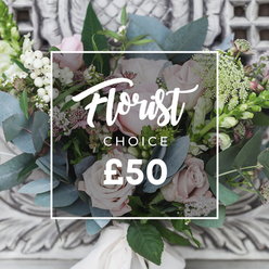 There is a gentle, English-cutting-garden serenity to this hand-tied bouquet: soft blush roses form the rounded heart of the arrangement, their velvet layers creating a tender focal point, while delicate white filler flowers and clusters of snowberry-like white berries scatter light through the stems. Eucalyptus leaves with their muted, dusty-blue tone create a cool backdrop and suggest that faint, aromatic green note when you lean in. The florist has balanced the denser, round rose heads with feathery sprays and slimmer, upright spikes-snapdragon-like stems that add height and a sense of movement-so the eye travels across textures and tones. Small, deeper pink or burgundy accents sit low in shadow to increase depth without overwhelming the delicate palette. A cream ribbon ties the stems, signalling a refined, handcrafted finish. Photographed in soft daylight, the bouquet radiates calm and understated joy, perfect for a new home in Clerkenwell, a well-wishing delivery to a table near Exmouth Market, or a quiet celebration among friends. As a floral designer I imagine the tactile contrast-the velvet of roses against the prickle of greens-and the comfort that contrast brings. We arrange and prepare similar bouquets for same-day delivery across Clerkenwell and neighbouring Farringdon, always aiming for that natural, unfussy elegance.