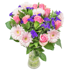 Arranged by the skilled hands of a Clerkenwell florist, this radiant bouquet captures the interplay of pale blush gerberas with timeless pink roses in a subtle dance of colour and texture. The arrangement glows softly, much like the morning sun diffused through Clerkenwell's historic windows, as varying shades of pink blend seamlessly-watercolor washes kissed by accents of deep purple statice, which dot the bouquet with jubilant energy. Crisp green leaves, dewy and full, encircle the blossoms, grounding the airy composition with cool freshness that whispers of St John's Square gardens after rain. Resting within an understated glass vase, the flowers seem almost to hover, inviting admiration. This bouquet, ideal for occasions from joyous get-well wishes to elevating a contemporary Exmouth Market flat, is crafted with an eye for detail and an appreciation of the vibrant yet tranquil atmosphere that defines Clerkenwell. Its presence is both cheering and relaxing, a floral tribute to careful art and the everyday joys of our community.