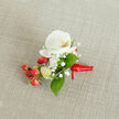 A softly lit, close-up image of an elegant floral buttonhole resting on a textured, oatmeal-coloured linen background, the kind of refined boutonniere a groom might wear to a Clerkenwell wedding near Exmouth Market. At the centre sits a pristine white Phalaenopsis orchid bloom, its broad, velvety petals unfurled in a gentle arc, with a creamy yellow and soft orange throat that brings a subtle warmth to the flower's cool white tones. Encircling the orchid, tiny white clouds of baby's breath create a delicate halo, their airy clusters adding lightness and a lace-like texture that contrasts with the orchid's smooth surface. Nestled to one side, glossy, round red berries catch the eye with their rich, festive colour, while a few paler green berry buds hint at freshness and new beginnings, like early shoots along Clerkenwell Green in spring. Lush green foliage in slightly different shapes and sizes fans out from behind the flowers and berries, giving depth and balance to the small arrangement and grounding the composition in natural colour. At the base, a vivid red satin ribbon is wrapped snugly around the stems and tied into a neat, compact knot, its short trailing ends lying flat against the fabric, suggesting the piece is ready to be pinned to a lapel or dress. The overall mood is one of quiet celebration and careful craftsmanship, a small but expressive floral accent perfect for weddings, proms, formal dinners, or winter gatherings across EC1, where a refined touch of nature close to the heart can complete a special outfit.
