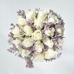 There's an effortless, graceful presence to this bouquet, as if it channels the hush of an early morning along Clerkenwell Green. At its core are crisp, white roses-plush, delicately layered, and suggestive of new chapters yet to unfold. These are threaded with slender sprays of pale lavender statice, whose petite blossoms lend a soft, lace-like texture against the roses' creamy petals. The bouquet rests on a simple, whitewashed background, making each bloom pop with radiant freshness. Gentle, natural light caresses the flowers, enhancing the velvety look and feel you might expect from blooms selected at the peak of their beauty. This design radiates calm elegance and enduring comfort-perfect for moments of reflection, expressing unspoken support, or celebrating the little victories of daily life in Clerkenwell. It's an arrangement that lingers in the mind like the faint trace of floral scent after walking through a quiet neighbourhood garden.