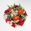Joyful as a Clerkenwell morning, this bouquet bursts with vibrant energy, perfect for celebrating life's brightest occasions. In the heart of the arrangement, radiant orange gerberas glow fiercely, their open faces exuding optimism and charm. Around them, rich magenta carnations and plush pink roses unfurl in decadent layers, their velvety textures inviting gentle touch and closer appreciation. Scattered among the bolder blooms, soft white alstroemeria and petite daisy clusters glisten like dew under early sunlight, adding a refreshing contrast that balances the palette. Framing it all, ample glossy greenery echoes the leafy paths of local parks, holding the design together with structure and subtle shine. The interplay of colour and texture is seamless, each flower collaborating in a harmonious melody that feels generous and welcoming-an impression reminiscent of Clerkenwell's open markets and art studios. Containing both warmth and a sense of occasion, this bouquet is tailored for moments of pure delight, such as birthday gatherings or special milestones celebrated along Clerkenwell Road. Its aromatic blend of roses and carnations, gently uplifted by the touch of fresh foliage, lingers in the air-a fitting extension of the florist's passion and the community's creative energy.