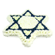 A richly detailed Star of David funeral wreath is presented against a spotless white background, its entire structure built from densely clustered chrysanthemums that create a soft yet striking presence. The star's outermost contour is drawn in immaculate white blooms, forming a broad, continuous border that traces every angle and point with clarity. Within this boundary, a white floral hexagon anchors the centre, serene and undisturbed, while six white triangular segments reach inward from each tip, giving the impression of the symbol gently folding in on itself in a gesture of embrace. Cutting through this field of white, two overlapping triangles are constructed from dark navy blue flowers, compact and velvety, which crisply delineate the well-known Magen David motif. The juxtaposition of deep blue against bright white immediately recalls Jewish ceremonial colours and the Israeli flag, strengthening the sense of identity, faith, and collective memory. The surface of the arrangement is smooth and uniform, each bloom turned outward so the multi-layered petals catch soft, even light, with no visible stems or foliage to distract from the pure geometry. This is clearly a professional tribute, crafted with the kind of quiet precision a family in Clerkenwell might seek when arranging a Jewish funeral, unveiling, or yahrzeit commemoration. Placed beside a memorial portrait, near a pulpit, or at a graveside in a nearby cemetery, the piece would communicate dignity, love, and continuity, using the language of flowers to honour a life and a long-standing tradition within the local community.