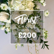A bold, abundant bouquet fills the frame, its whites and creams framed by an array of greens that feel freshly picked from a Clerkenwell garden. The highest impact blooms are large, velvety roses and hydrangeas, with fully open blossoms and others in tender bud, all mingled with delicate white flowers that whisper of garden freshness. A parade of green foliage-slim eucalyptus, broad leaves, and curling tendrils-trails with natural ease, giving the arrangement a sense of movement and life, as if it were a living centerpiece. The soft light from the neutral background makes the whites glow, while some elements cascade gracefully toward the lower edge, hinting at a spray crafted to adorn a doorway or altar. Superimposed at the center is a semi-transparent white square frame; inside, the script reads 'Florist Choice Today' above a large, bold '?200' in a clean sans-serif. The whole composition announces a premium offering, ideal for weddings, remembrance, or a statement display in a stylish office or venue near Exmouth Market. It conveys luxury, quality, and immediate availability, with the assurance of fresh stems and careful handling, and it's designed for same-day or next-day delivery across Clerkenwell, Smithfield, and the broader area.