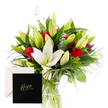 From Clerkenwell's sunlit window, this bouquet unfolds with the quiet authority of a well-told story. White lilies sit at the heart of the arrangement, their large trumpet shapes luminous and serene, their satin petals catching the light with a soft, almost clinical clarity. They are surrounded by lush, cool greenery-deep, verdant leaves, wispy eucalyptus, and slender ferns-that provide a cooling backdrop, like a green wall in an old city courtyard around Exmouth Market. Red roses punctuate the design with fire and warmth, their velvety petals and classic perfume offering a note of passionate respect. Between the blooms, unopened buds hold promise-the next moment of beauty to come, a sign of ongoing celebration. The overall effect is radiant yet balanced, a gentle contrast between precision and tenderness, much like a well-tended street garden along Exmouth Market. A clear glass vase anchors the stems, giving the bouquet an airy height and a sense of easy accessibility. Light pours in, outlining every leaf and petal in crisp, fresh lines, while the arrangement radiates a sense of calm strength. This is a composition crafted for honouring someone's resilience or marking a significant win, with the accompanying card read 'Hero' to keep the sentiment intimate and enduring. Available for same-day delivery across Clerkenwell, Farringdon, and nearby Islington, it carries a message of heartfelt admiration-elegant, earnest, and distinctly local.